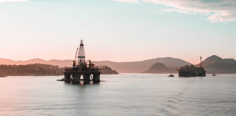 Scenic view of oil rigs at sunset